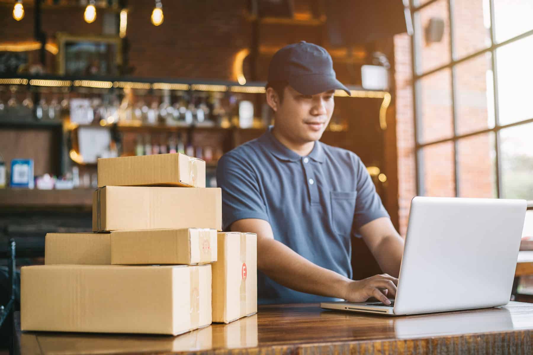 A man sitting at a table with boxes on the counter.